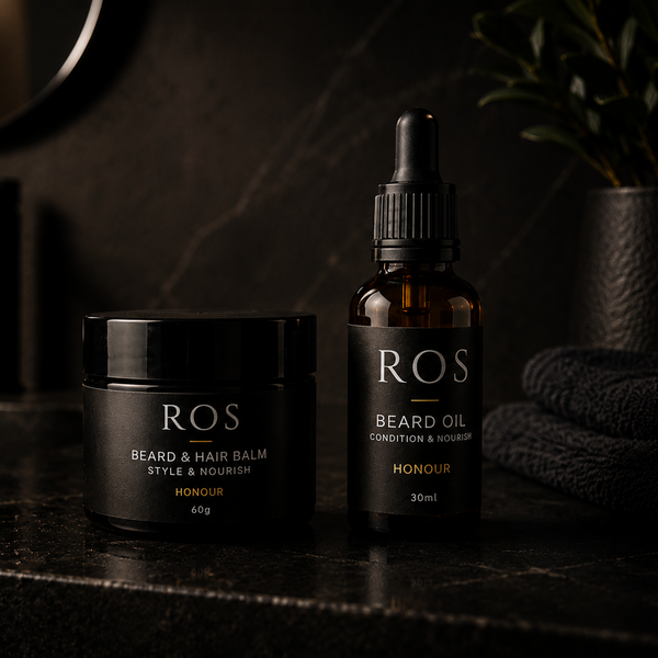 ROS beard and hair care products on a dark surface with a candlelit background
