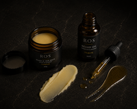 ROS Beard & Hair Balm and ROS Beard Oil set on a dark textured background, featuring an open balm jar, a bottle, a dropper, and two dollops of the products.